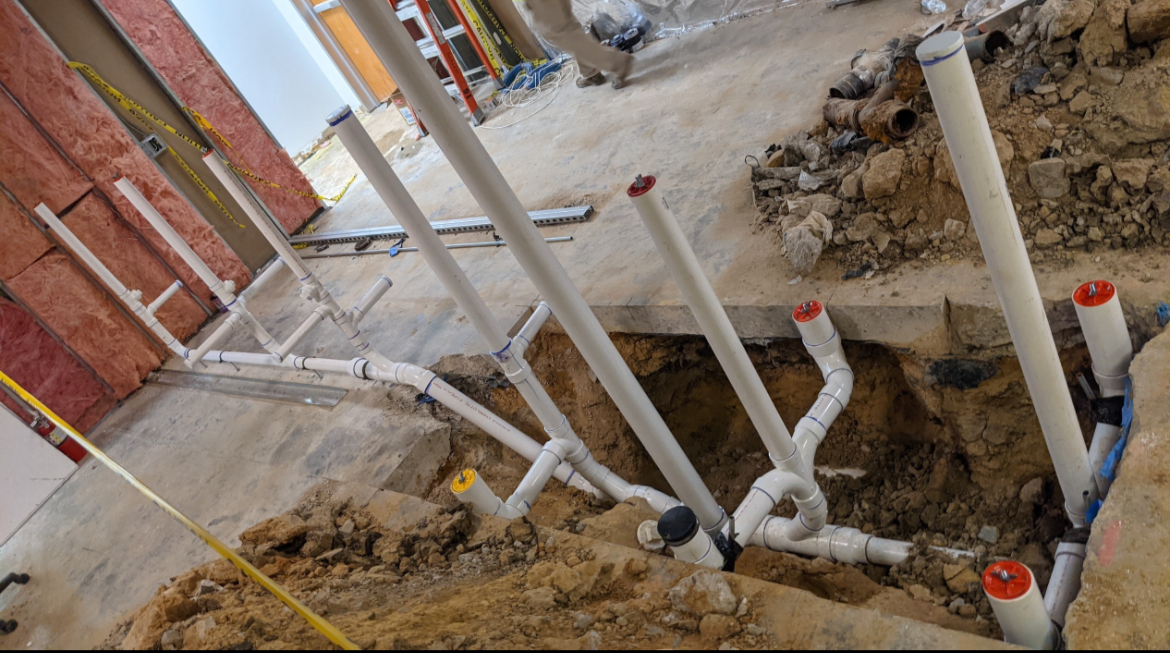Commercial main sewer line replacement and 30-foot under-slab excavation tunnel beneath a building foundation by a DFW master plumber.