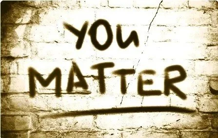 Graffiti on a white brick wall that reads, "You Matter" in black spray paint.