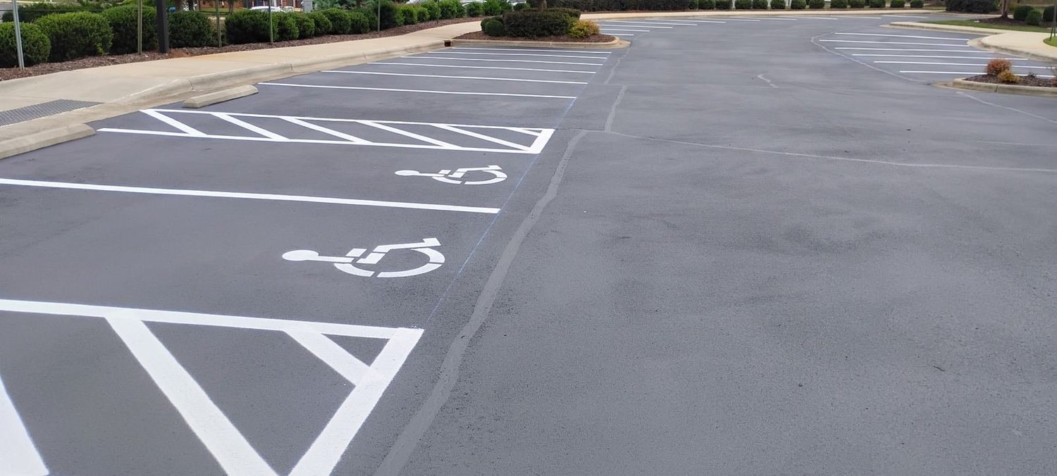 Apartment community parking lot after sealcoating and striping, ADA spaces marked