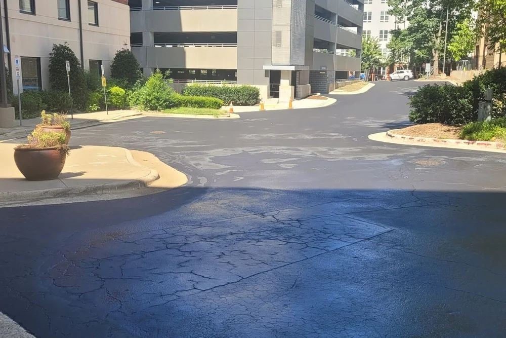 Fresh sealcoat on one section of a parking lot while the rest stays open