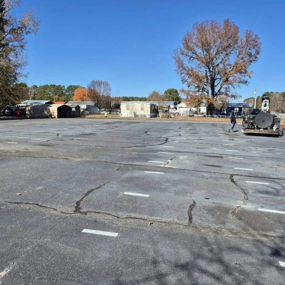 Cracked, faded asphalt parking lot before seal coating