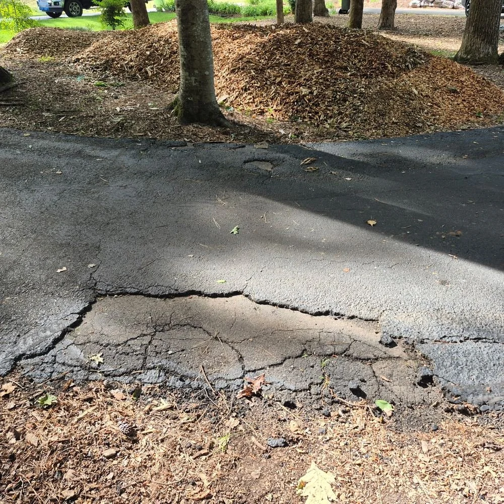 Broken, crumbling asphalt edge before repair