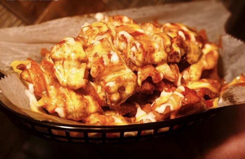 Spicy Chicken and Waffle Fries - Diced Chicken on a bed of waffle fries with ranch honey mustard and buffalo sauce