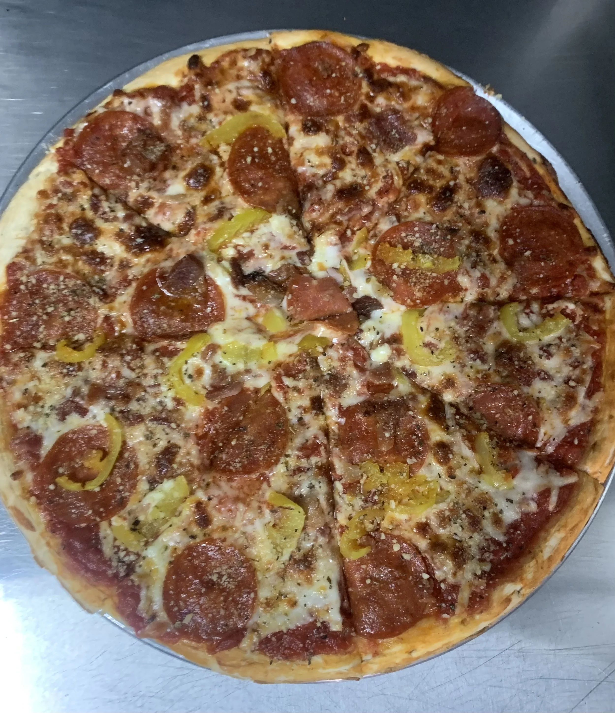 A pepperoni and Banana pepper pizza on a metal tray