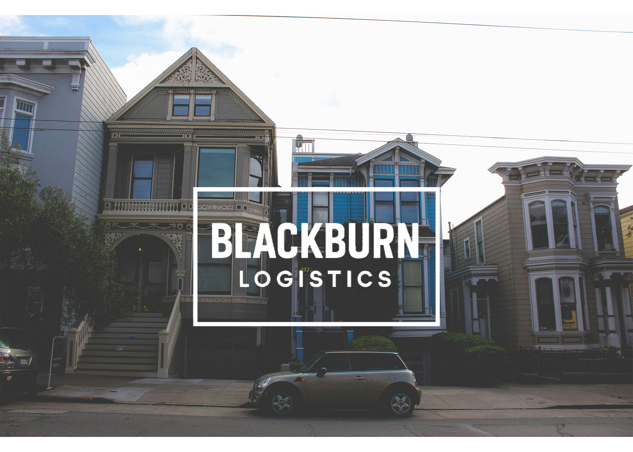 Colorful Victorian houses on a city street with a car parked in front, and the logo of Blackburn Logistics overlaying the image.