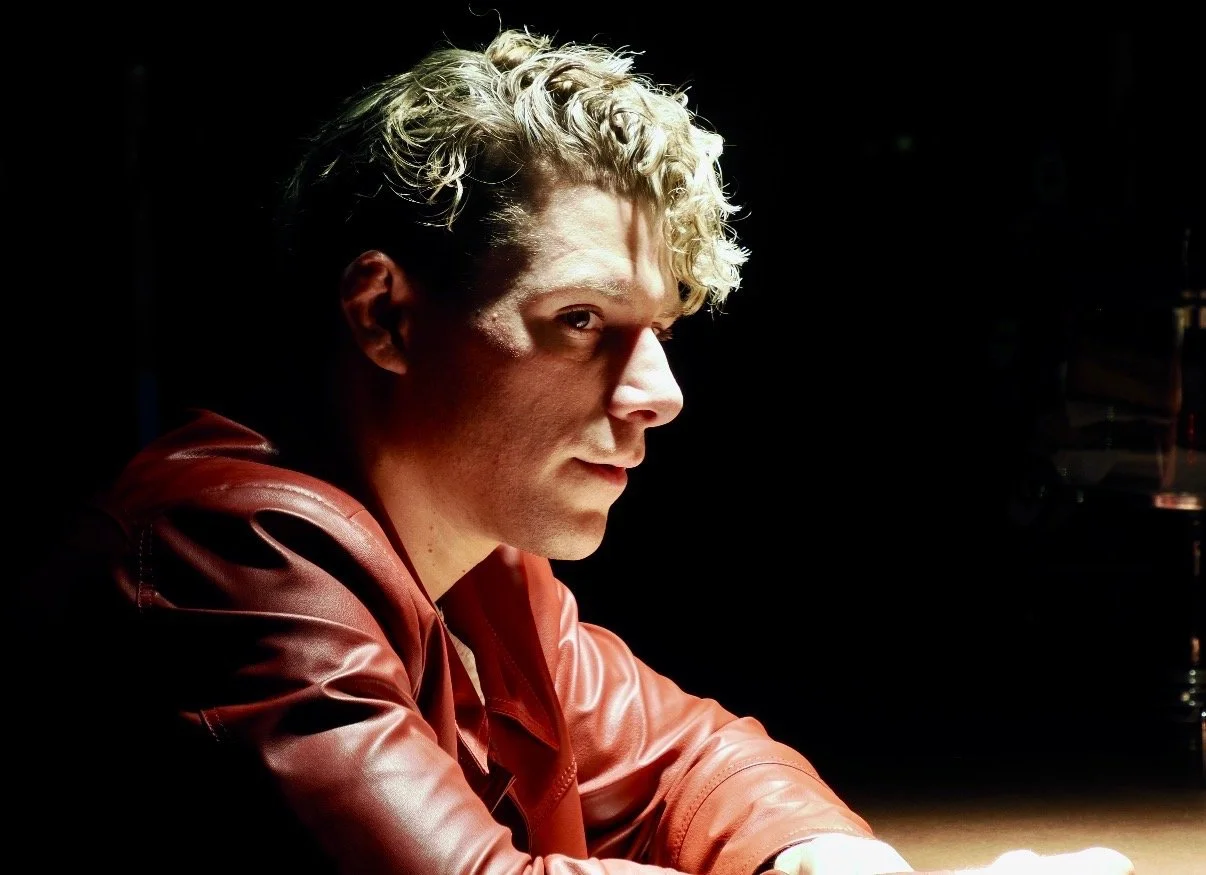 Travis acting in dramatic lighting making eyes at a woman