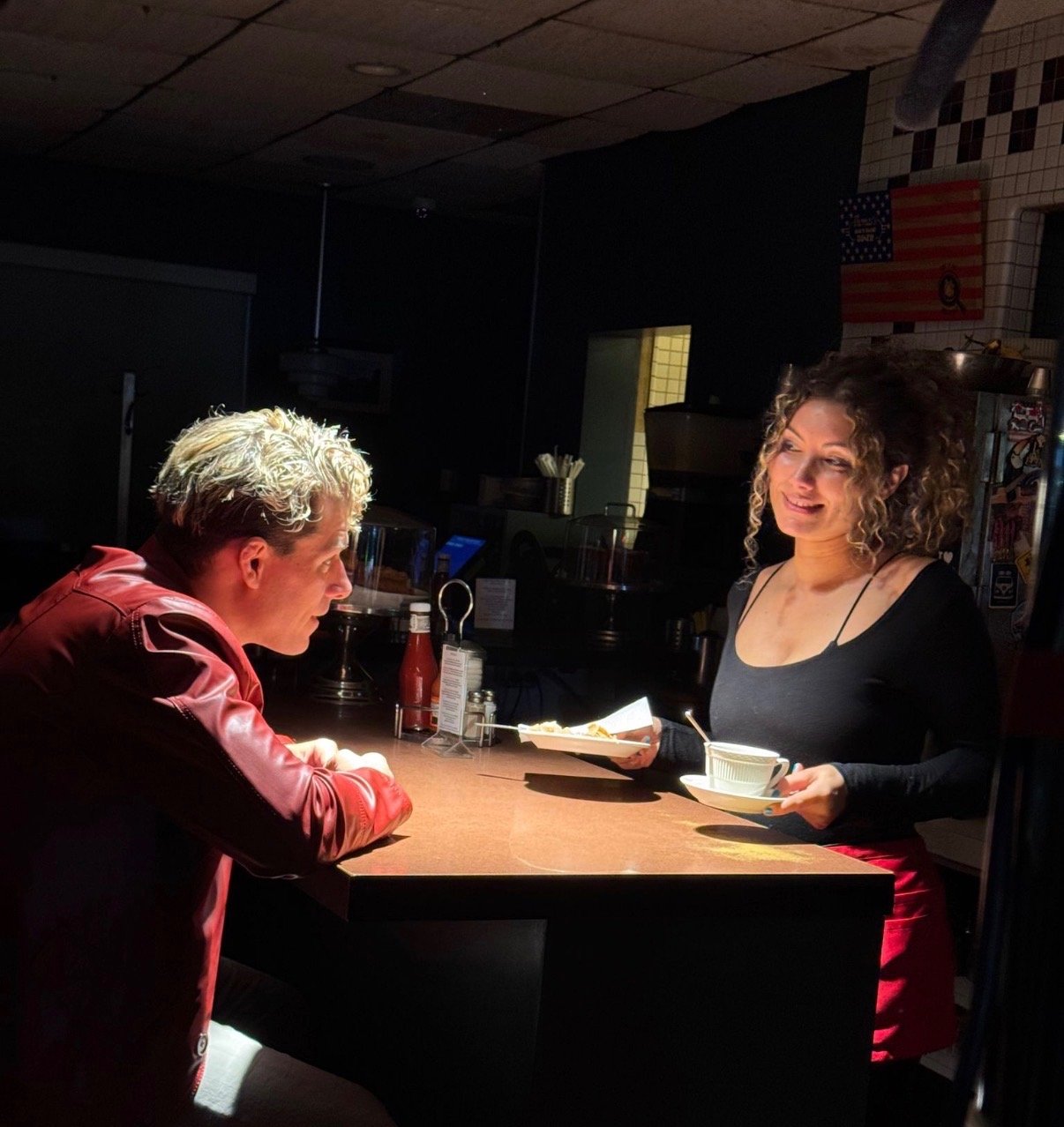 Travis acting, talking to a bartender