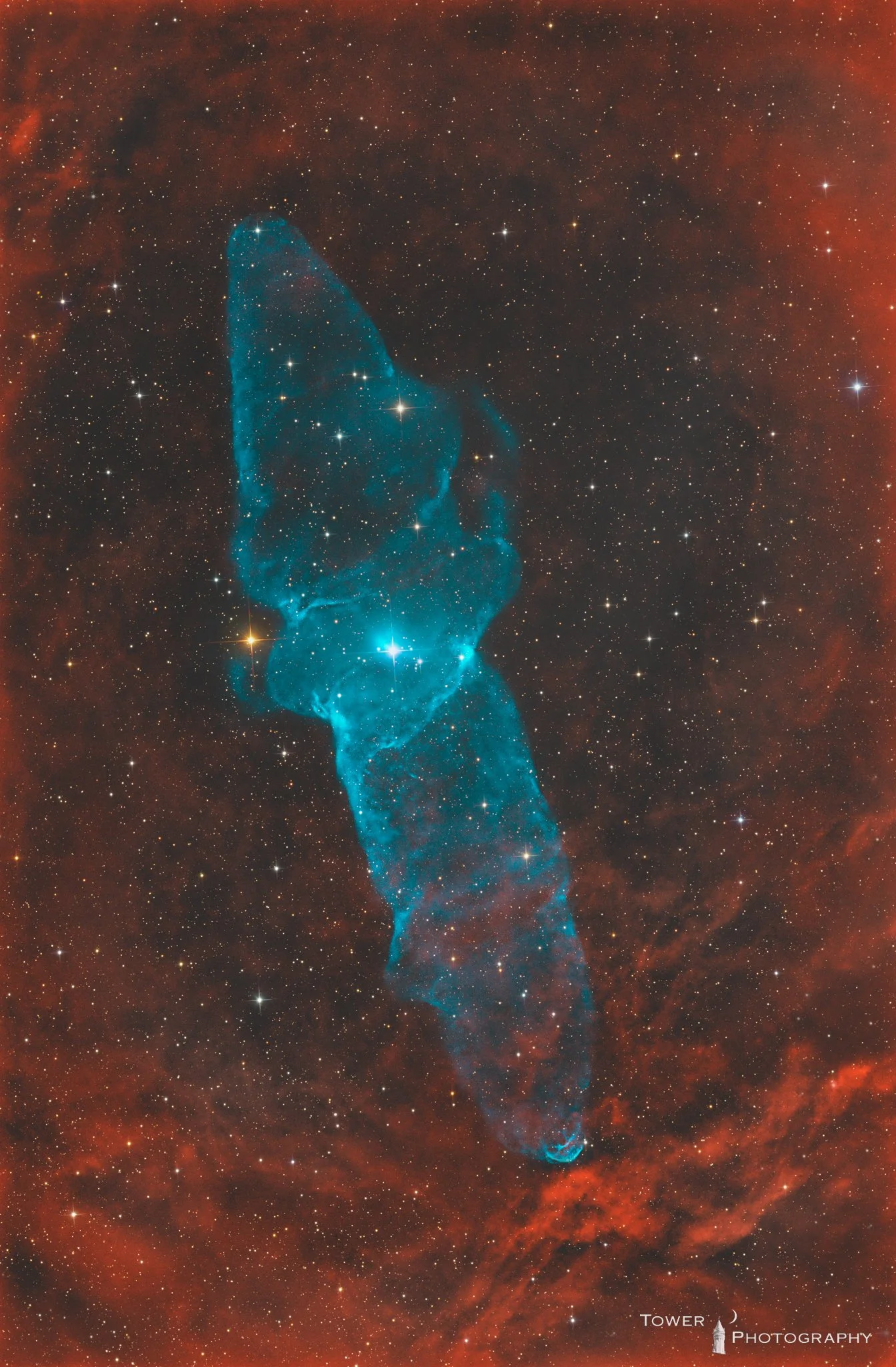 A colorful image of a nebula in space with a star as a bright focal point. The nebula has an elongated shape with blue and orange-red clouds of gas and dust surrounding numerous stars.