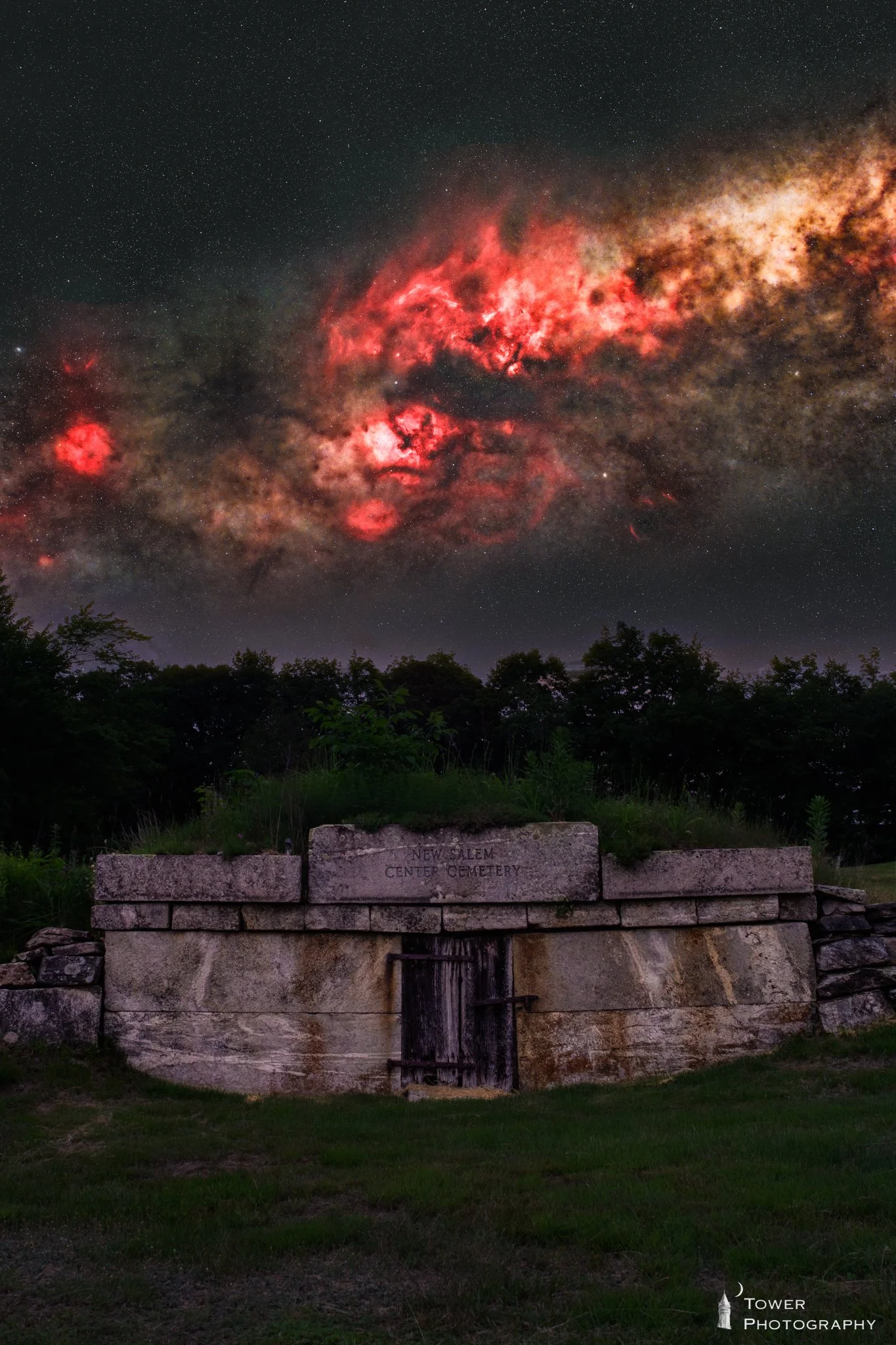 Night sky filled with stars and a vibrant red nebula, with a stone memorial or monument inscribed 'New Salem Center Cemetery' in the foreground.