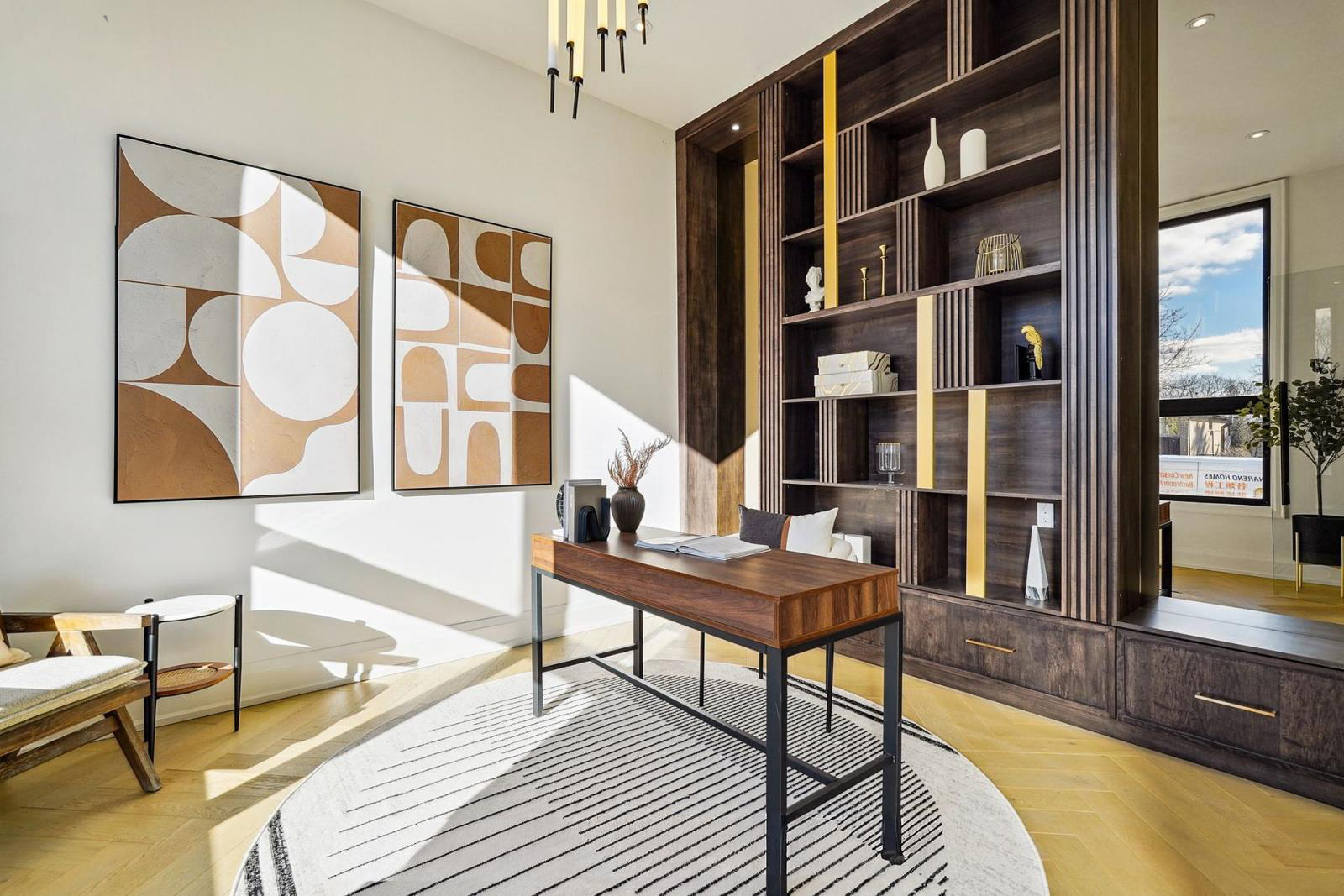 Modern office with a wooden desk, gold and black accents, abstract wall art, and large windows with sunlight streaming in.