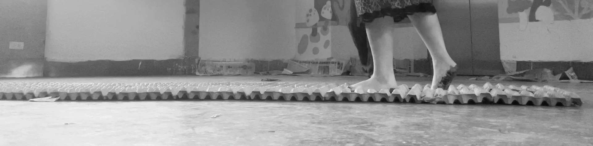 Person walking barefoot on foam tiles in an indoor space.
