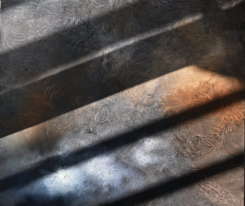 Close-up of a textured, patterned metal surface with black shadows cast across it.