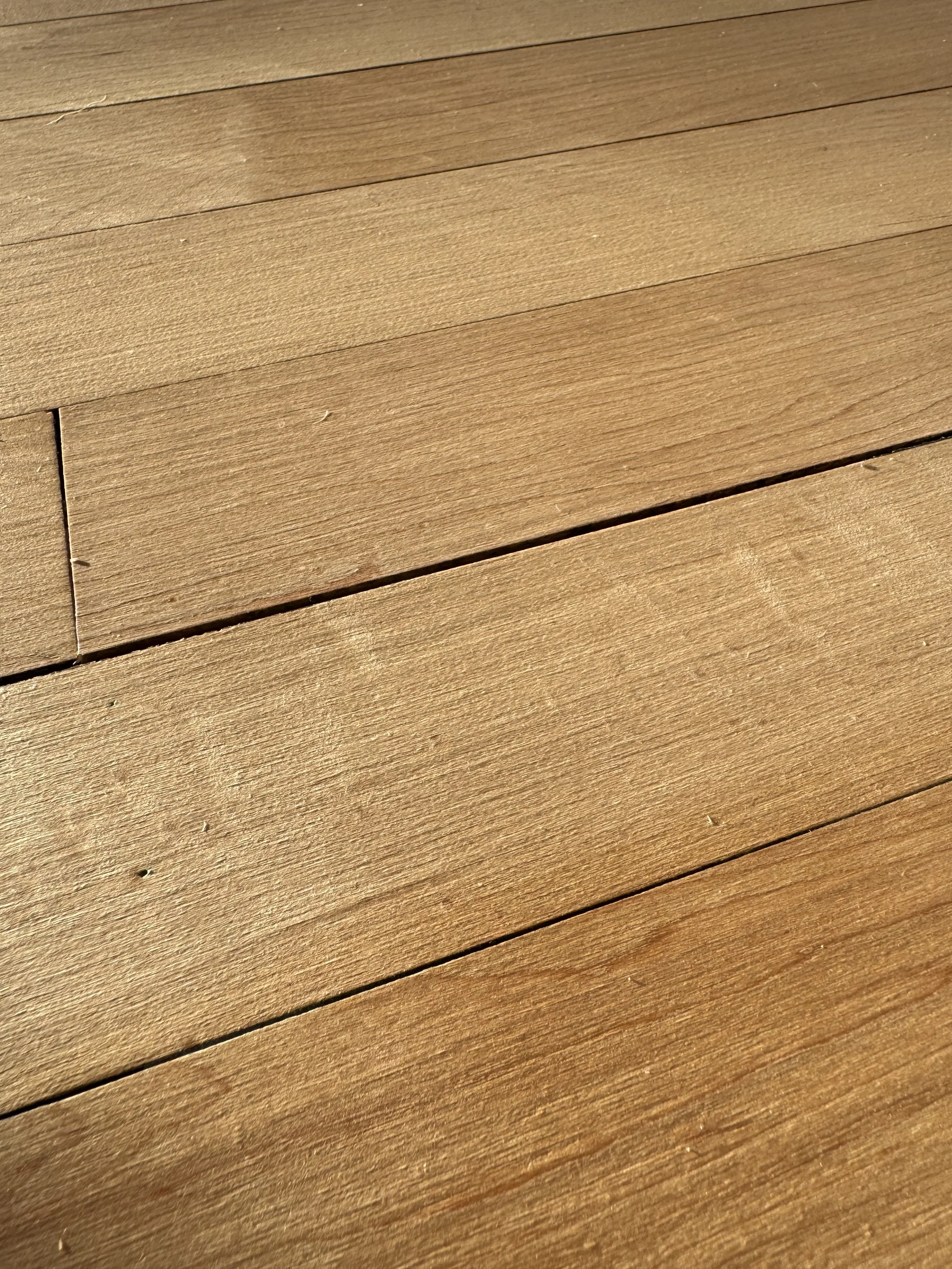 Close-up of a wooden surface with horizontal planks and a brown finish.