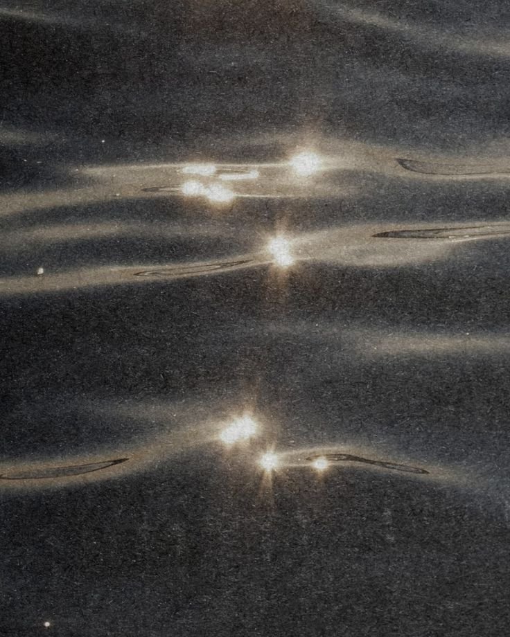 A photograph of five bright spots of light in space, with swirling patterns of dust and gas around them, resembling distant stars or galaxies.