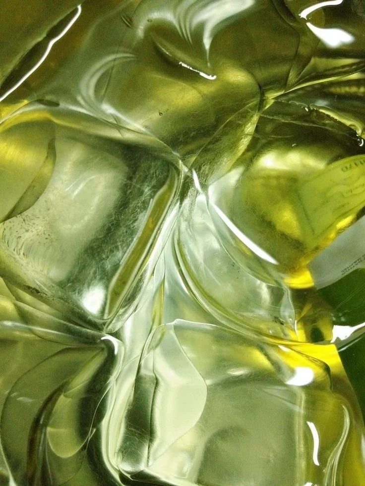 Close-up of shiny, metallic, gold-colored plastic or foil objects with smooth, reflective surfaces.