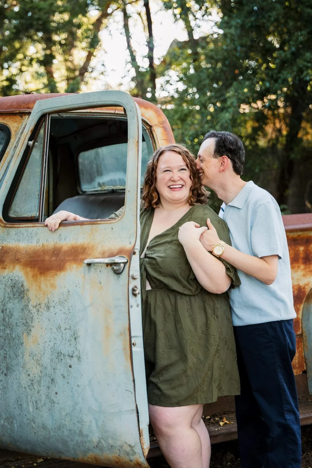 Couple kissing by a rustic truck at Sekrit Theater