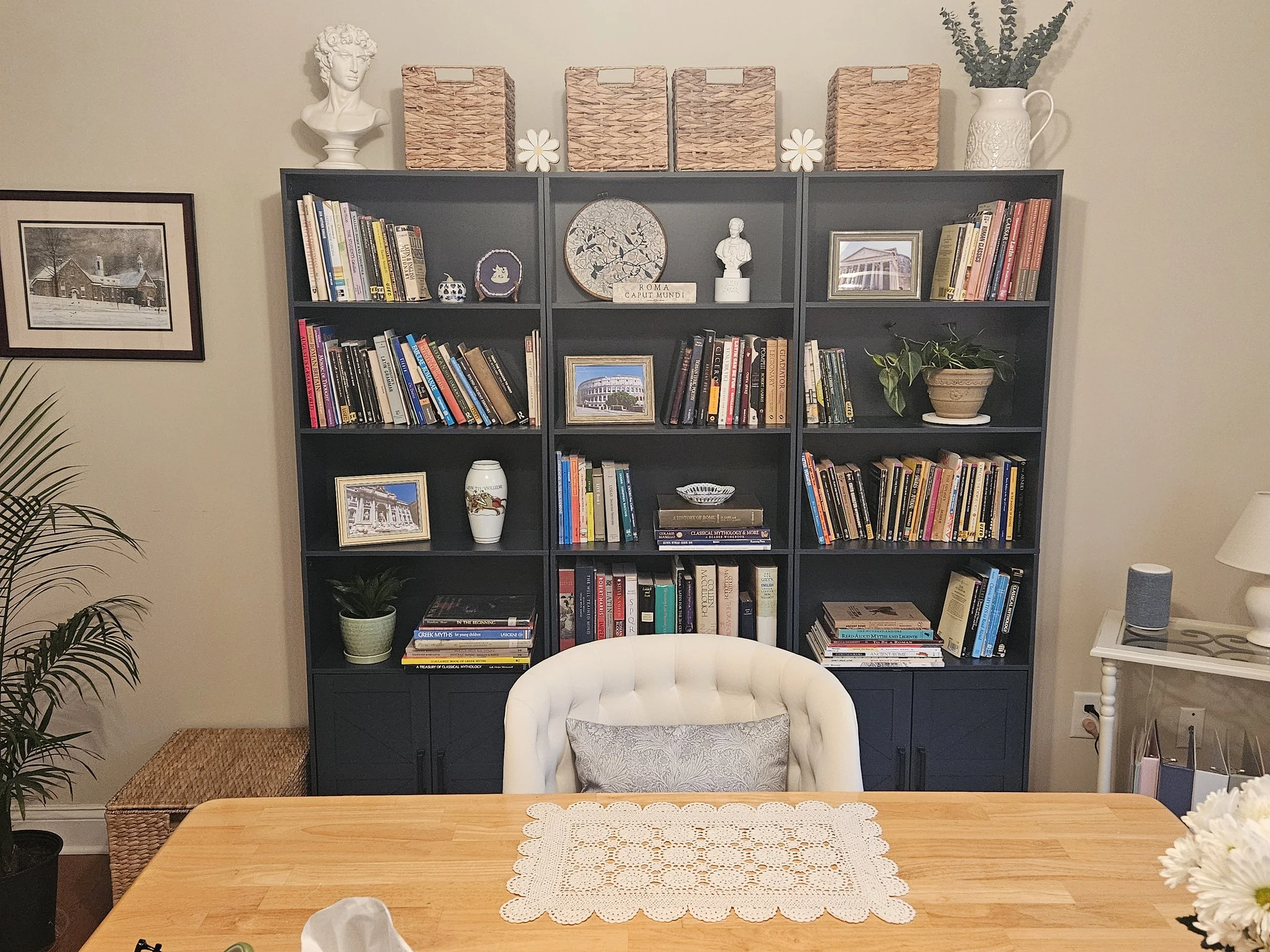 Desk with chair in office with bookshelves in background.