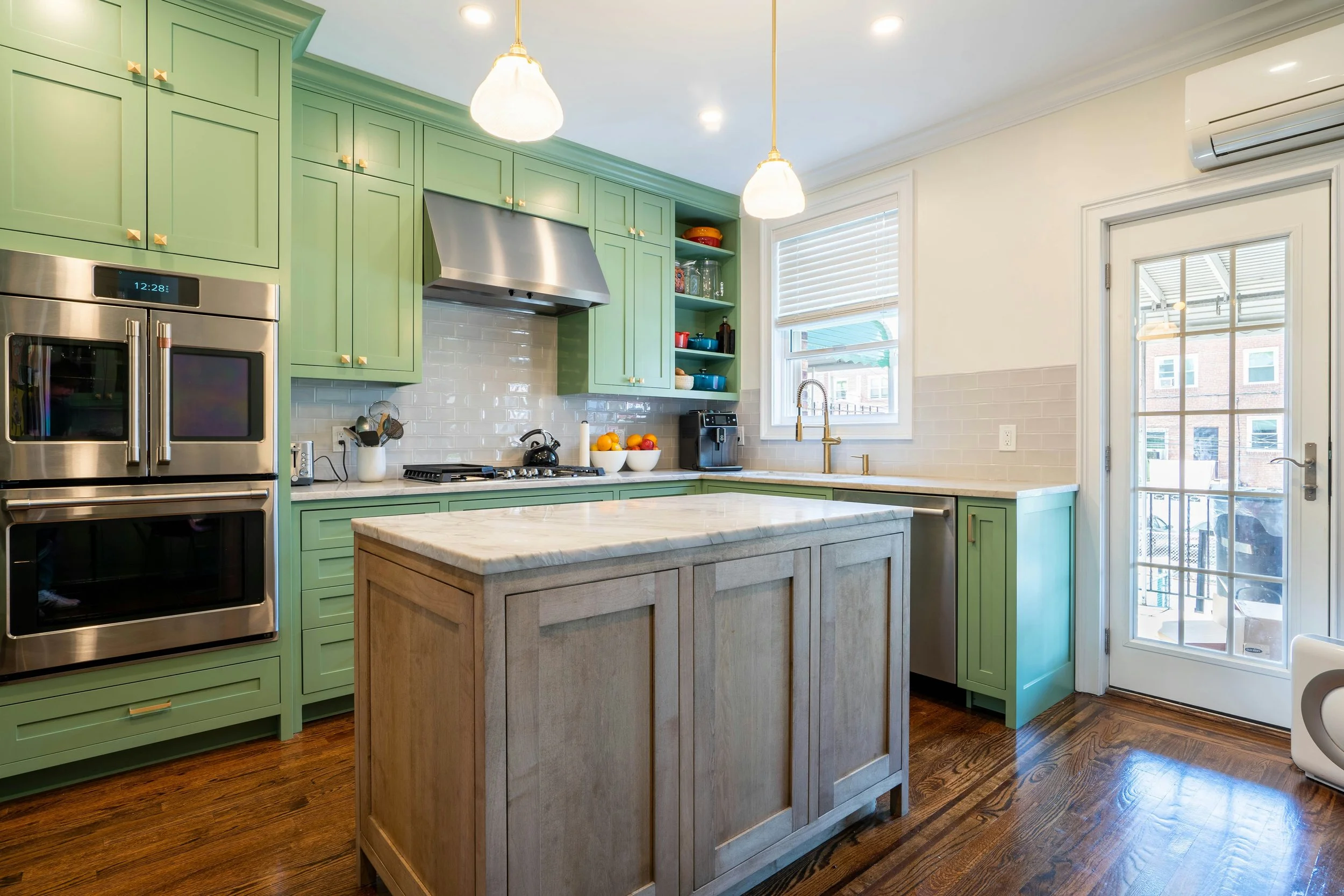 Light kitchen island countertop paired with green cabinetry; surface and cabinet design inspiration.