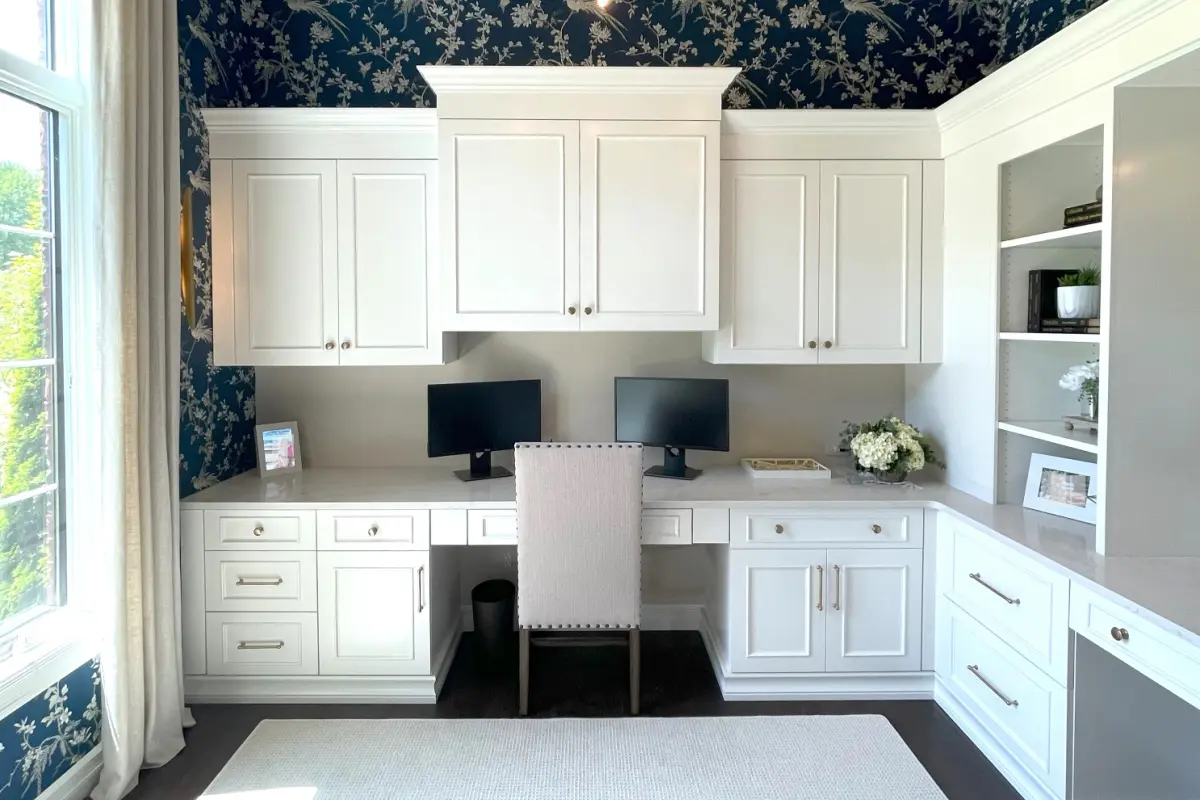 White built-in home office with a fitted desk, drawers, upper cabinets and open display shelves; design inspiration.