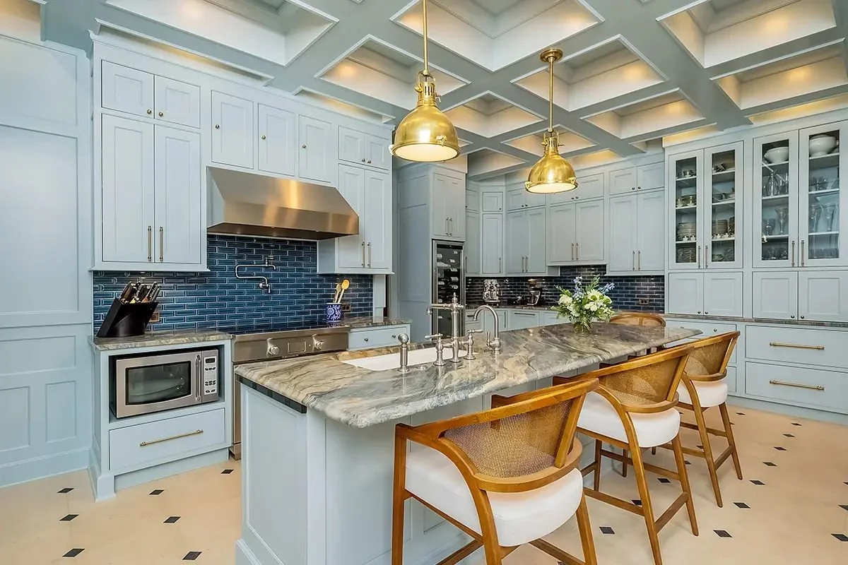 Kitchen design reference: white cabinets, marble island, gold pendant lights and black tile backsplash.