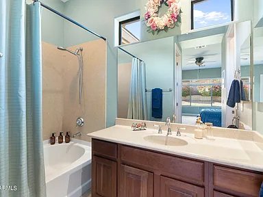 Bathroom with a mirror, vanity, and window