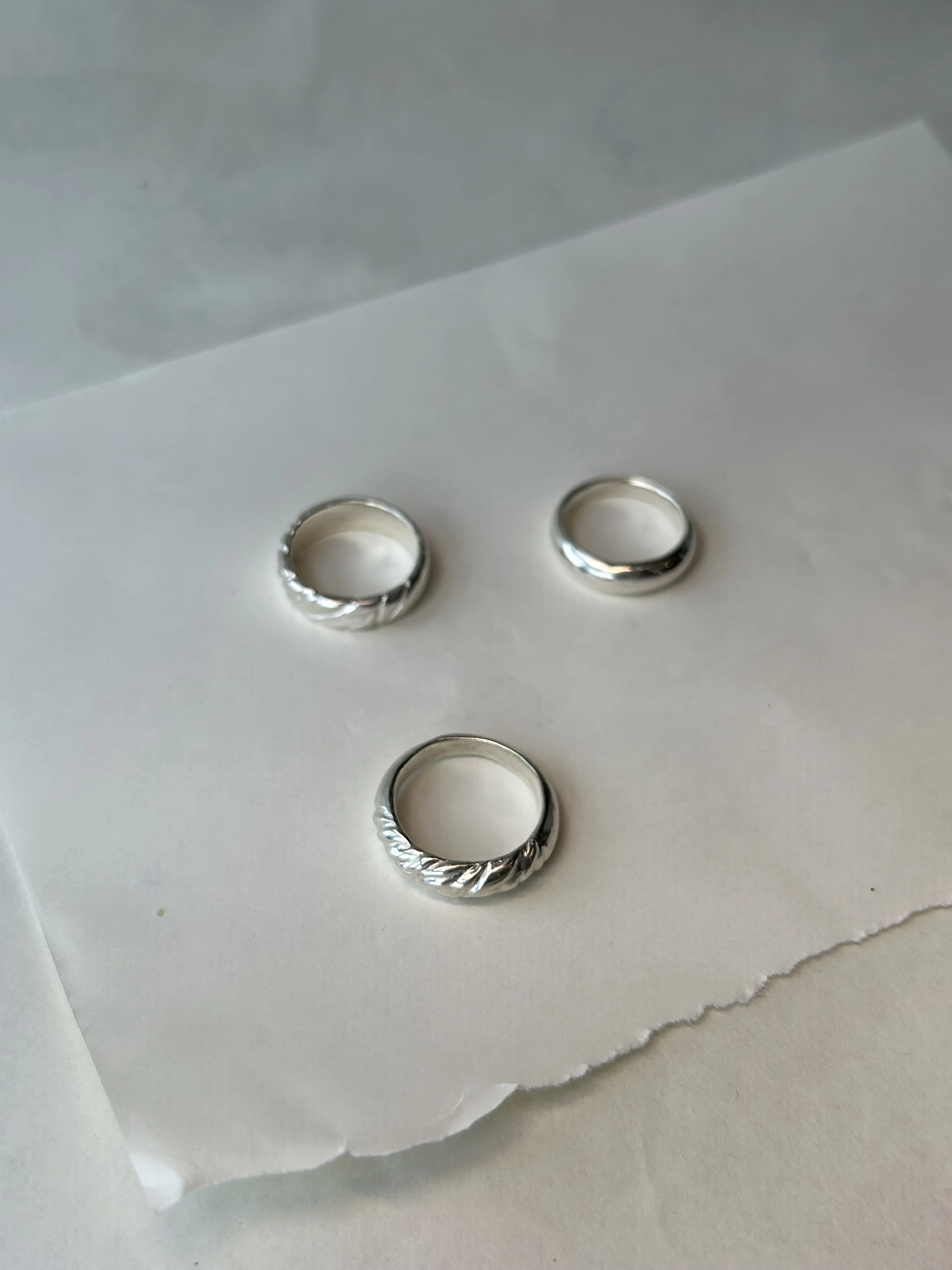Three piece collection of sterling silver rings.