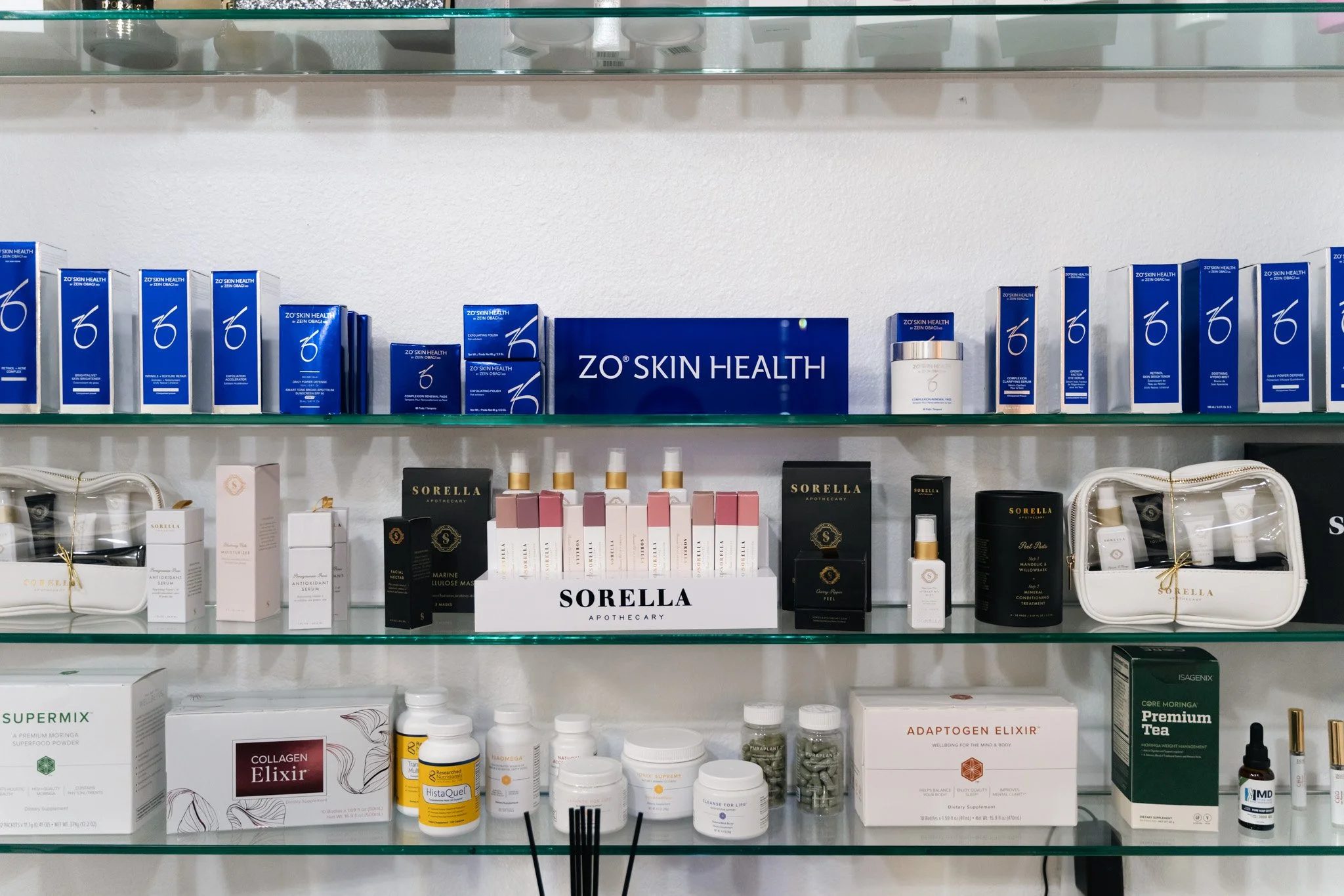Display shelf with skincare, beauty, and health products, including brands like Zo Skin Health, Sorella, Collagen Elixir, and Adapogen Elixir.