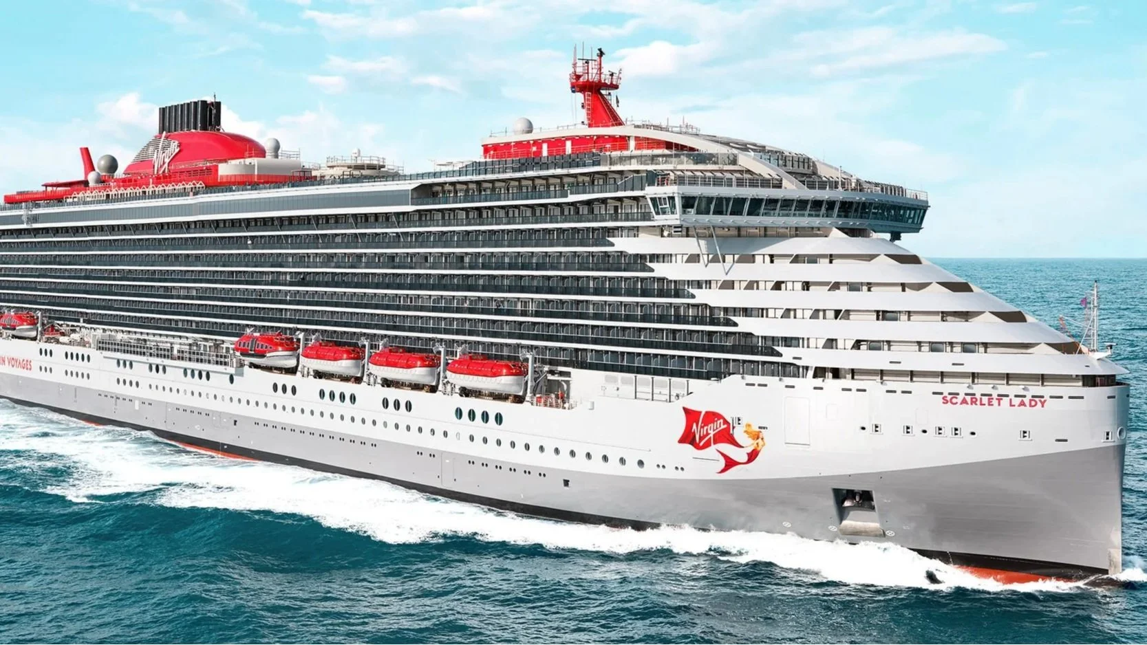 A large white cruise ship named Scarlet Lady sailing on the ocean with a clear sky overhead. The ship has multiple decks with balconies and red lifeboats along the side. The Virgin logo is visible on the front of the ship.