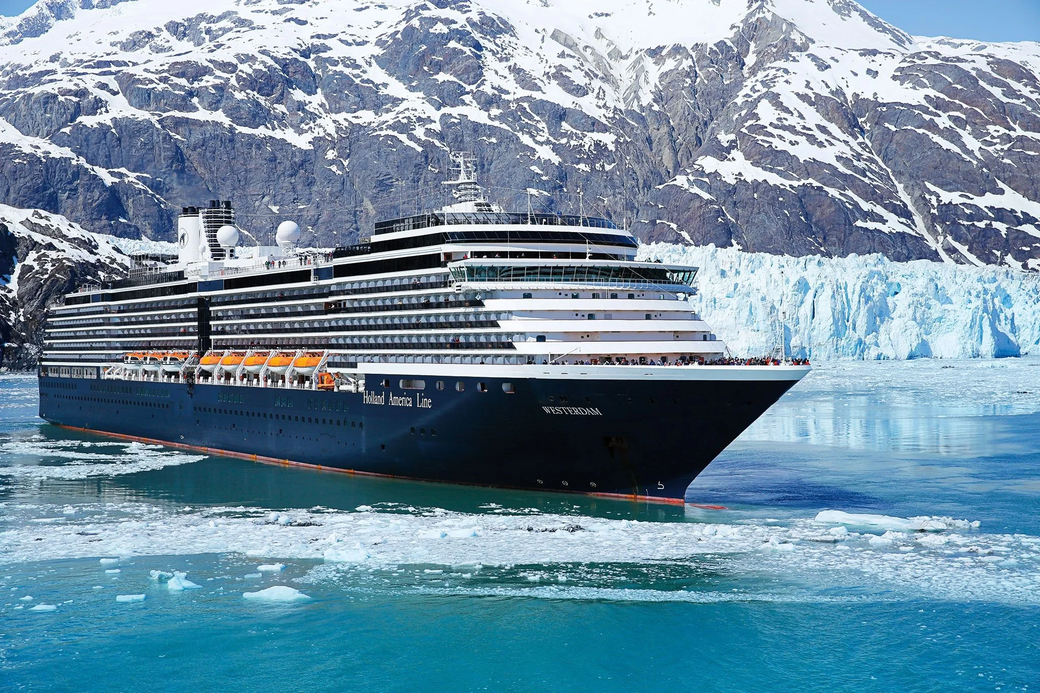 Holland America Line cruise ship sailing near Alaska glaciers offering premium Alaska and Europe cruise vacations