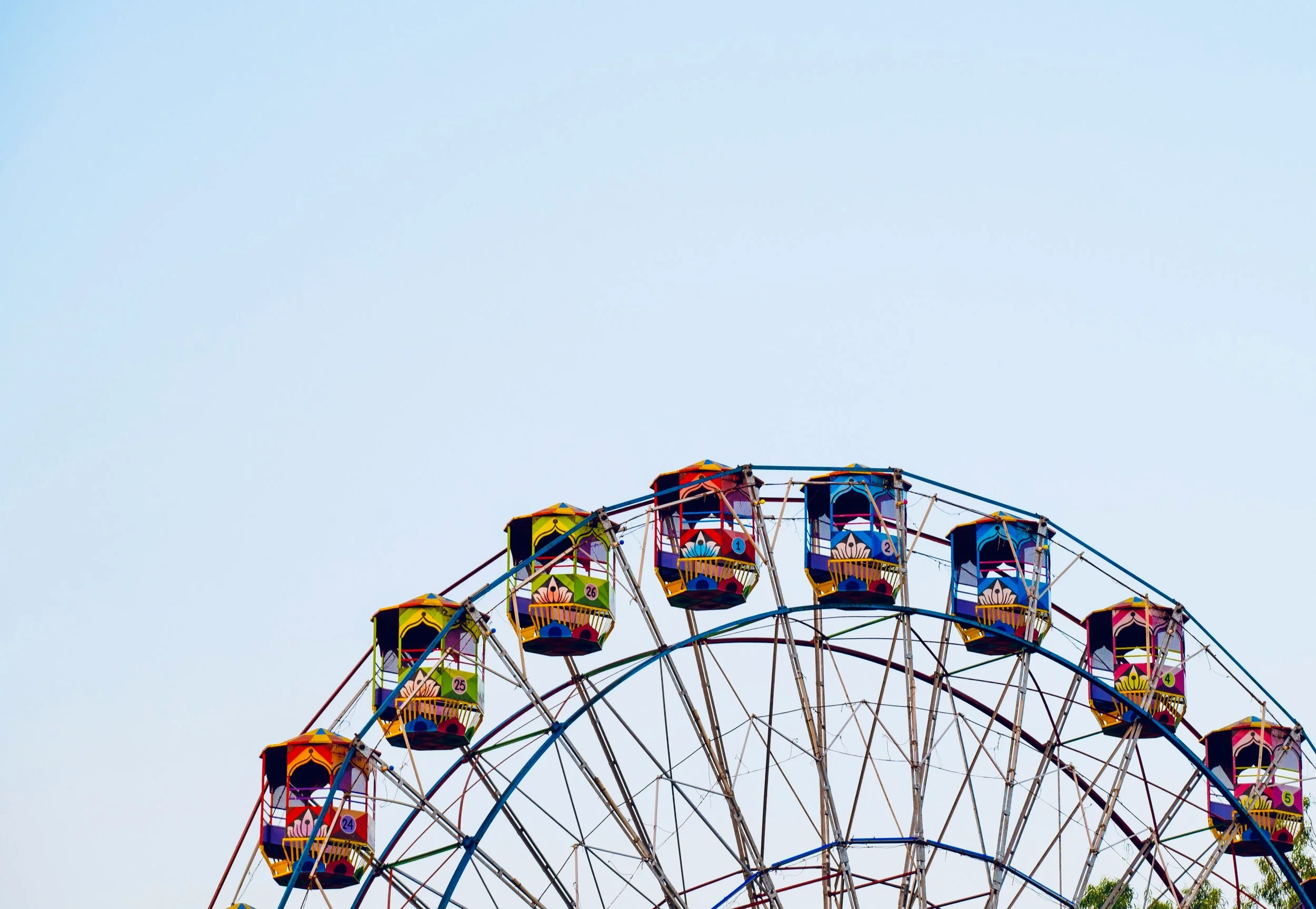 Colorful Ferris wheel against a clear blue sky.