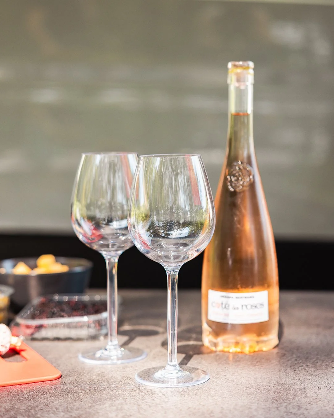 Twee lege wijnglazen en een fles rosé wijn op een tafel