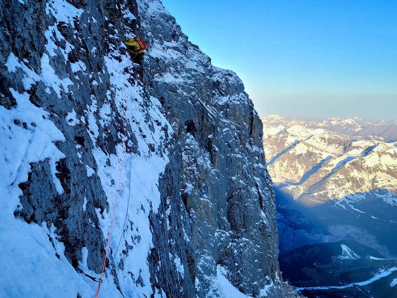 Kletterer im Götterquergang in der Eiger Nordwand. Dramatische Morgenstimmung.