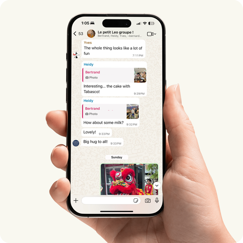 Hand holding iPhone showing WhatsApp family group chat export screen