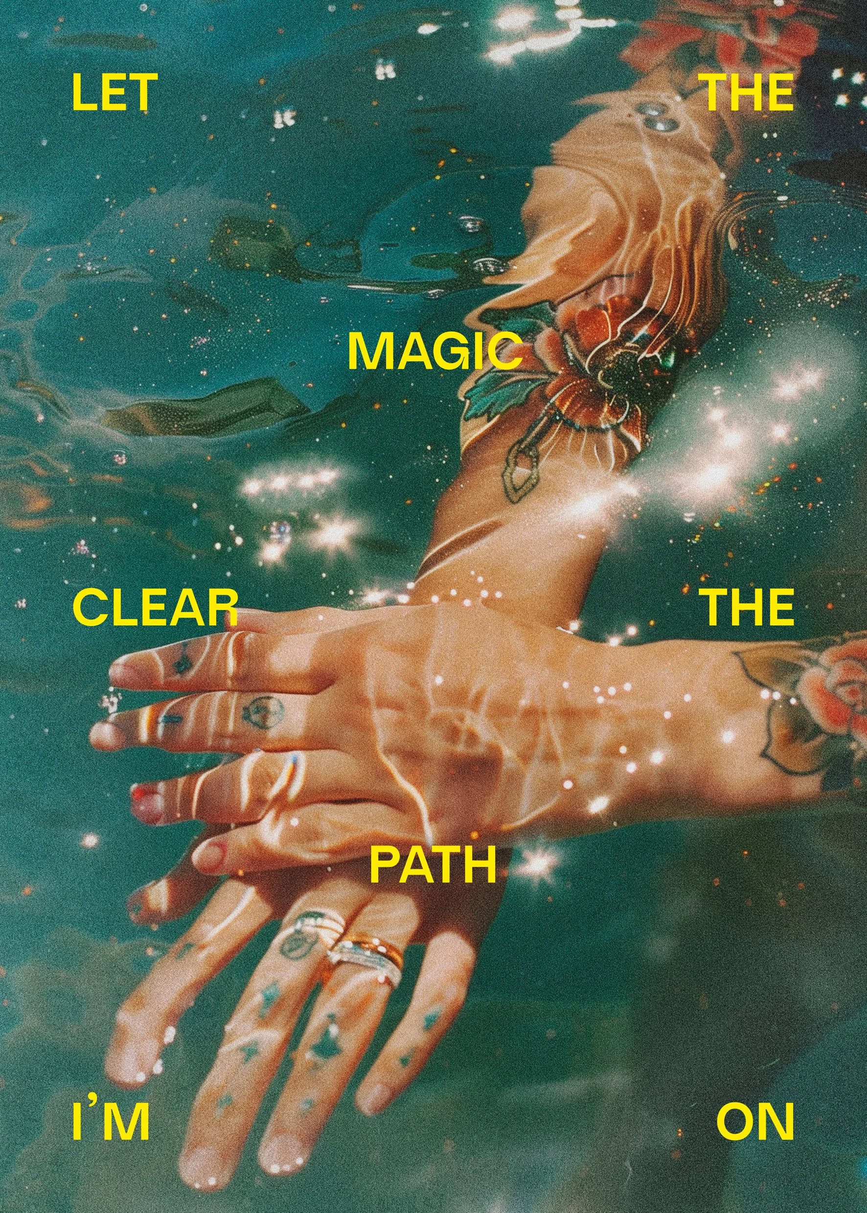 A person with tattoos on their hands is underwater, holding and intertwining their fingers, with sparkles and light reflections around them. Yellow text overlay reads: 'LET THE MAGIC CLEAR THE PATH I’M ON'.