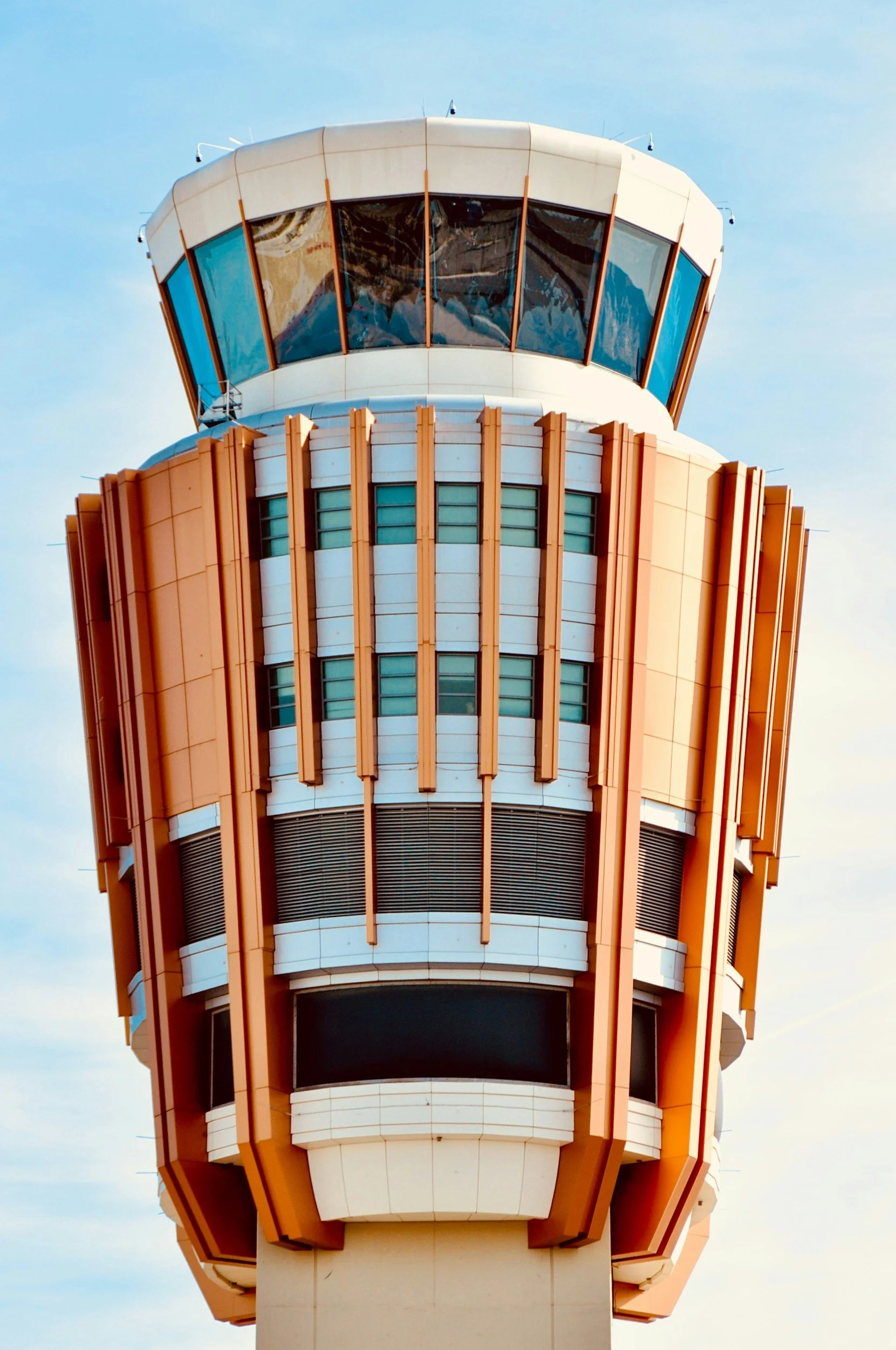 Close-up of the control tower at an airport, with a clear blue sky in the background.