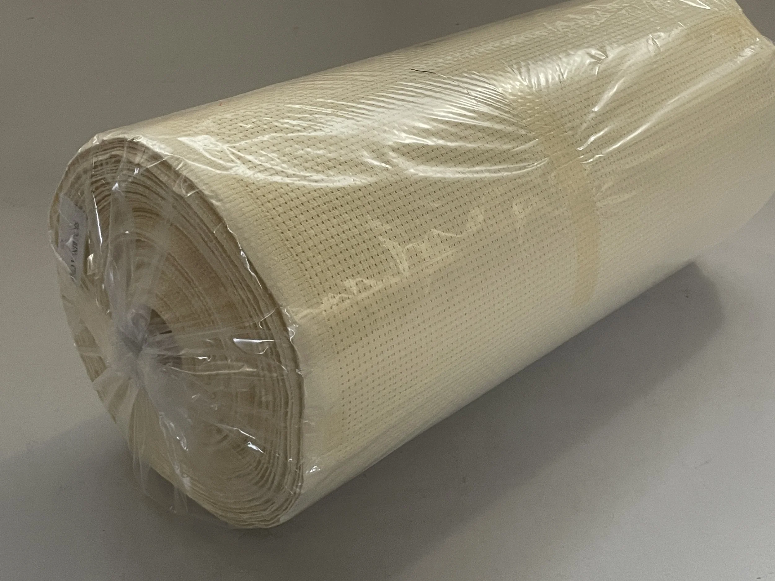 A roll of beige textured plastic mesh material wrapped in clear plastic