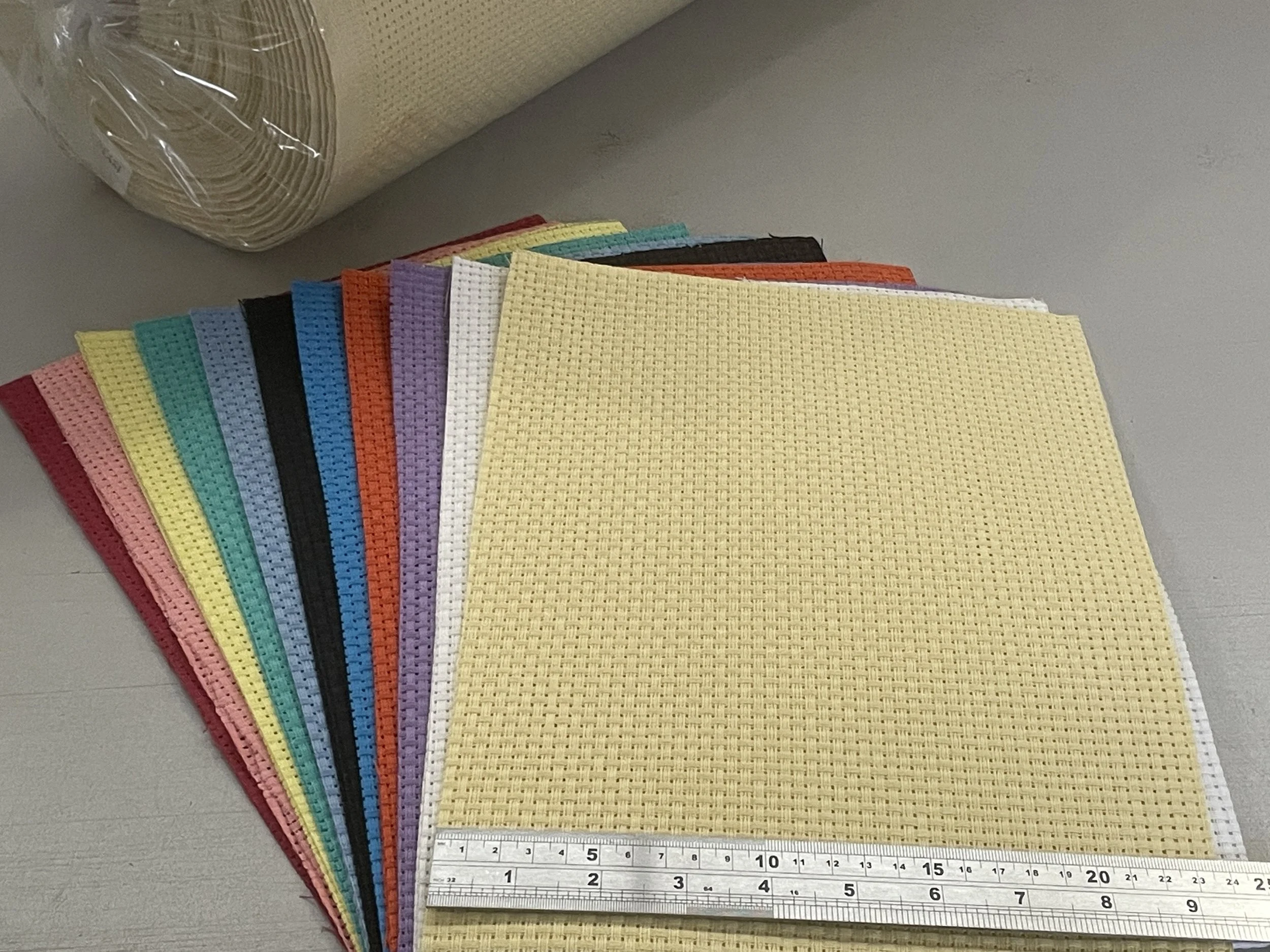 Stacked craft fabric pieces in various colors with a ruler at the bottom.