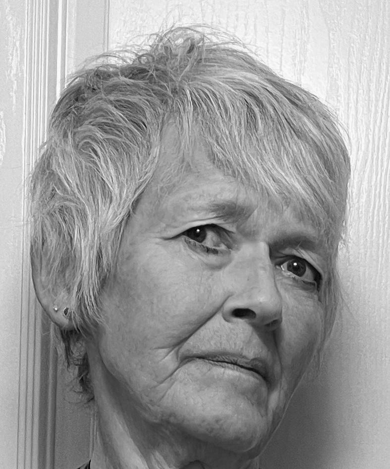 Close-up black and white photo of an elderly woman with short, light-colored hair, looking slightly to the left with a serious expression.