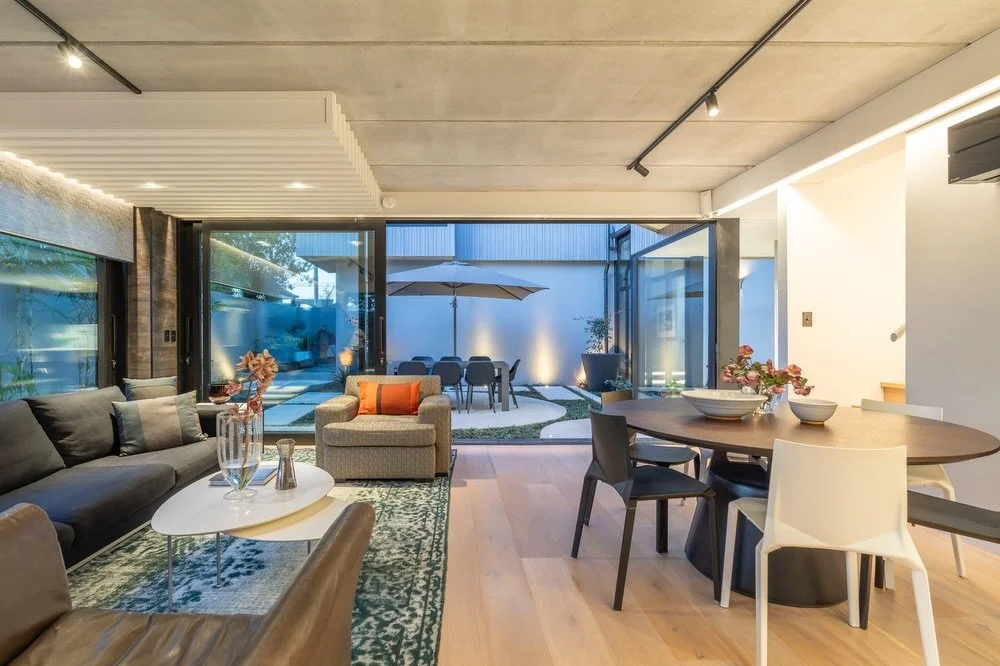 This lounge anchors the home with it&rsquo;s exposed concrete ceiling, full-height sliders, and a water feature that runs the entire length of the glazing.