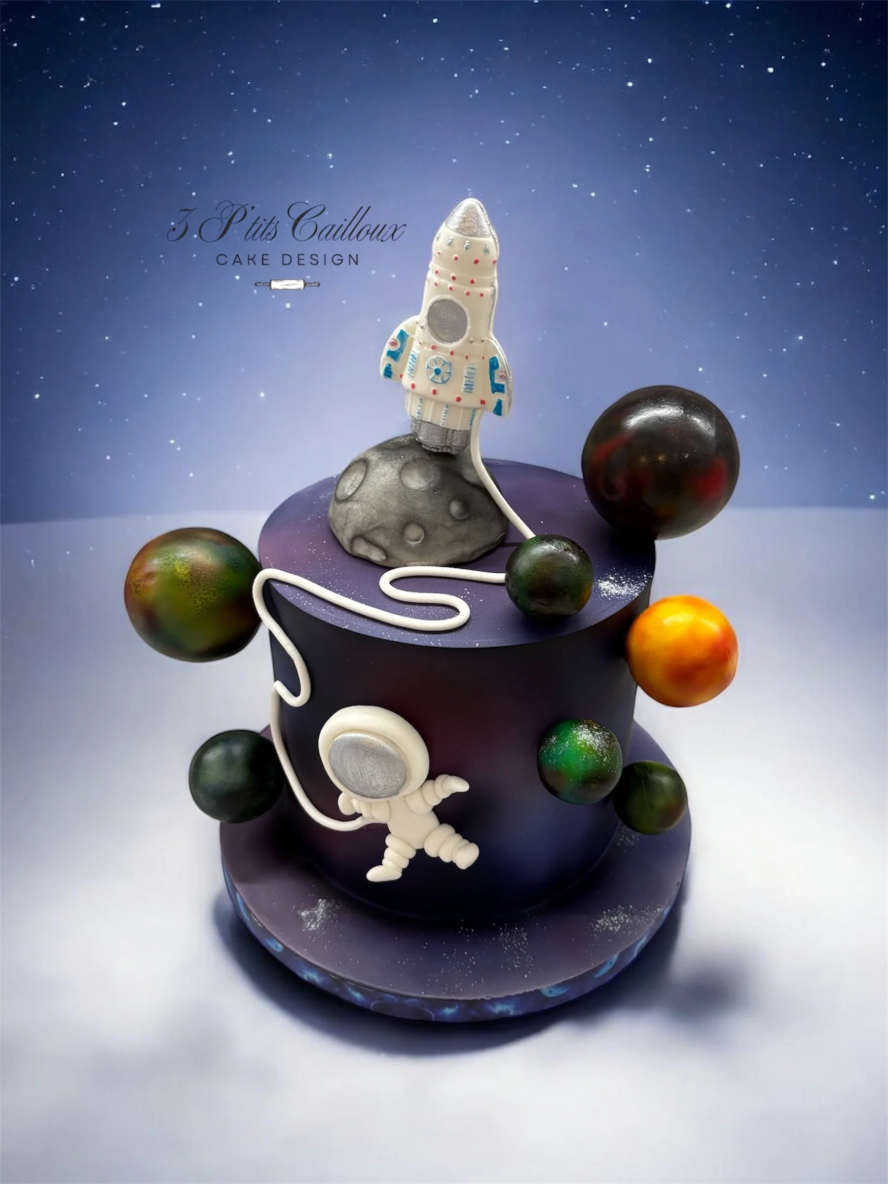 Gâteau avec thème spatial et astronautes en chocolat, décoré avec une fusée, planètes et étoiles, sur fond étoilé.