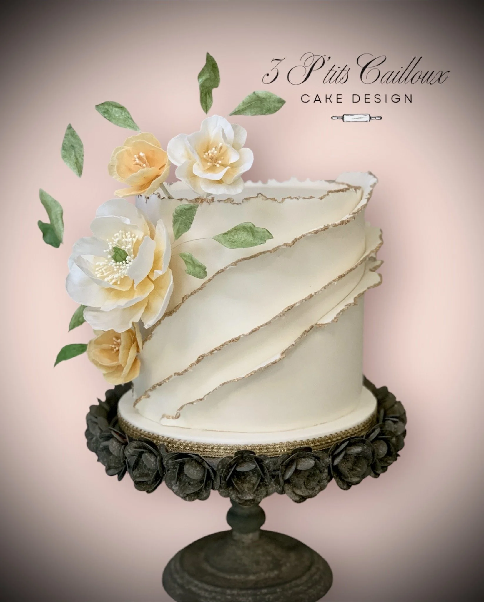 Gâteau de couture avec décor de fleurs en pâte à sucre et texture réalistique sur un socle noir, avec texte indiquant '3 P'tits Cailloux' et 'Cake Design'.
