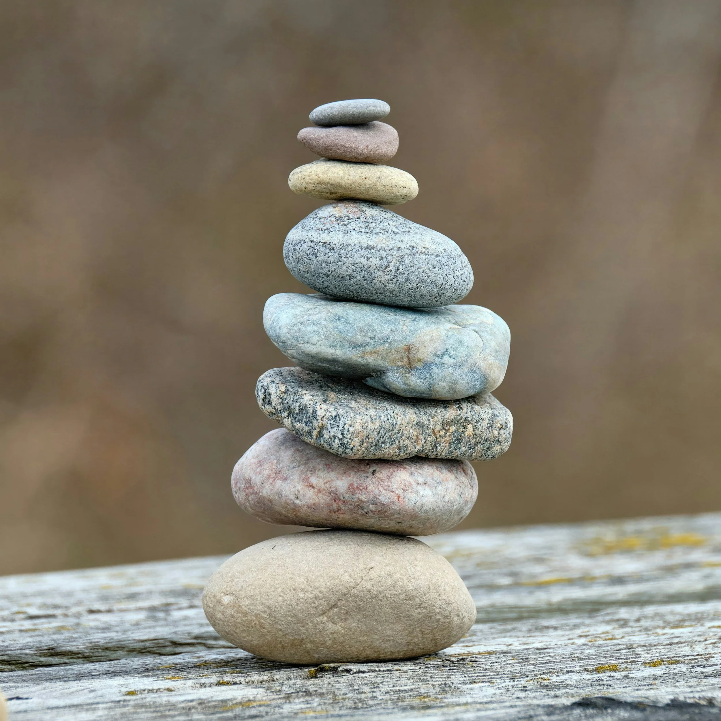 A stack of smooth, natural stones balanced on top of one another, representing calm, balance and simple wellbeing.