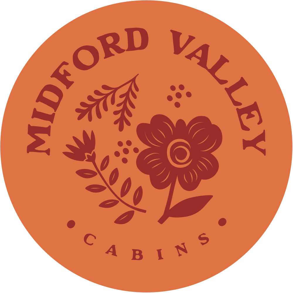 A circular logo for Midford Valley Cabins with a floral design and the text 'Midford Valley Cabins'.”