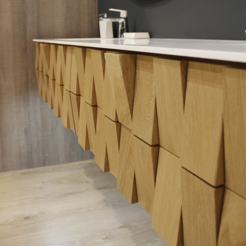 Dessus d'une commode ou d'un meuble en bois avec un motif géométrique en forme de V, dans une pièce avec un sol en bois clair et un mur gris foncé