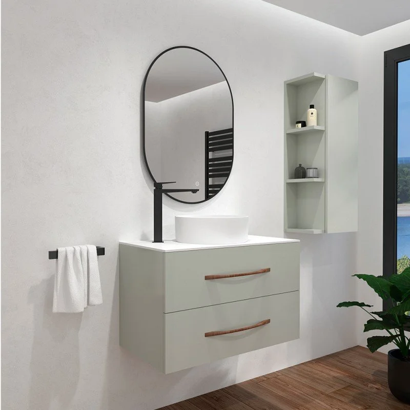 Salle de bain moderne avec un miroir ovale, un lavabo sur un meuble blanc à deux tiroirs avec poignées en bois, une étagère murale contenant des produits de toilette, une serviette blanche suspendue et une plante verte à droite près de la fenêtre.
