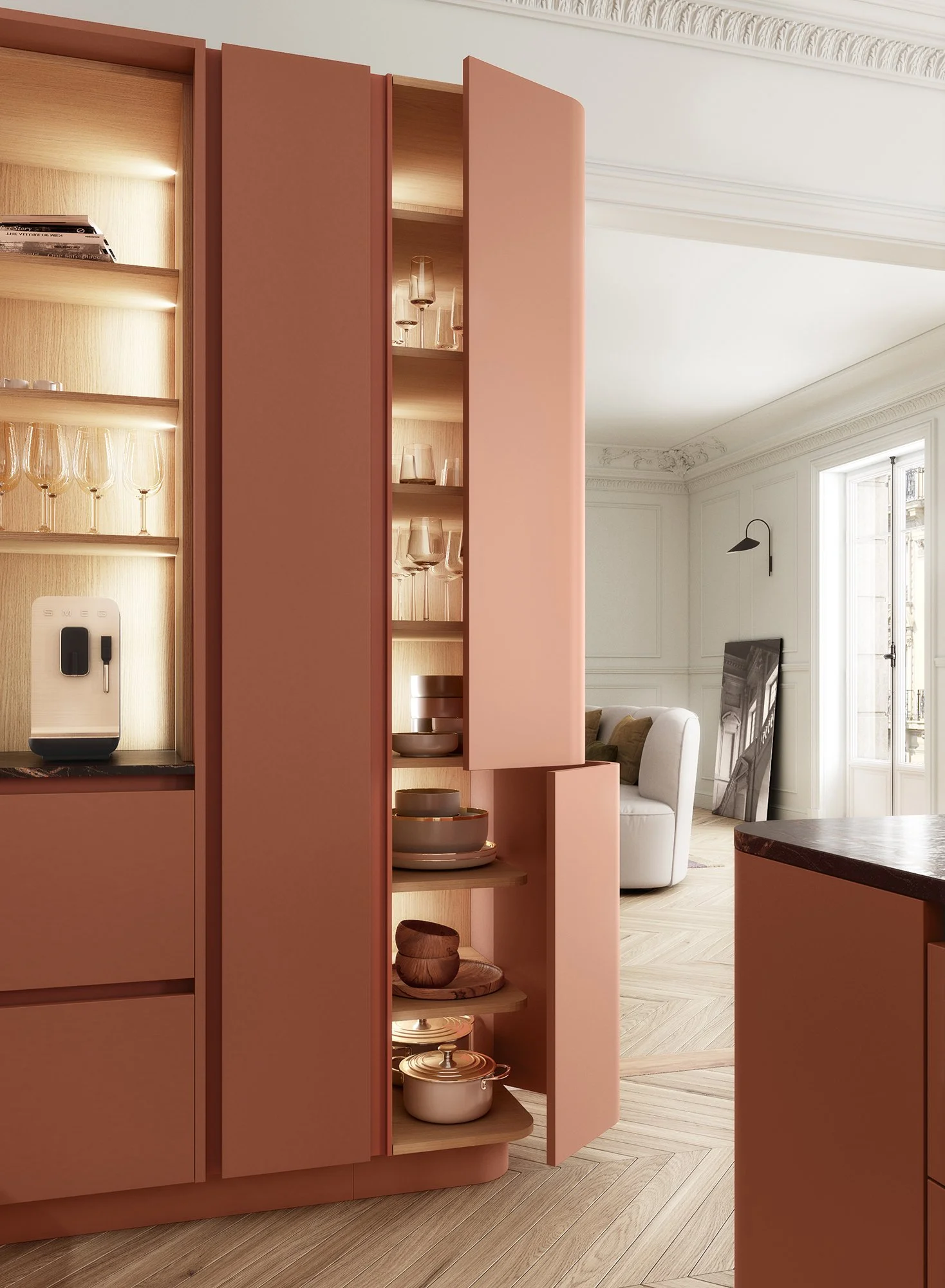 Une cuisine moderne avec un mur de rangement en rose contenant des assiettes, des bols, et des verres en verre, avec un intérieur en bois clair. En arrière-plan, un salon avec un canapé blanc, un tableau noir, et une grande fenêtre laissant entrer de la lumière naturelle.