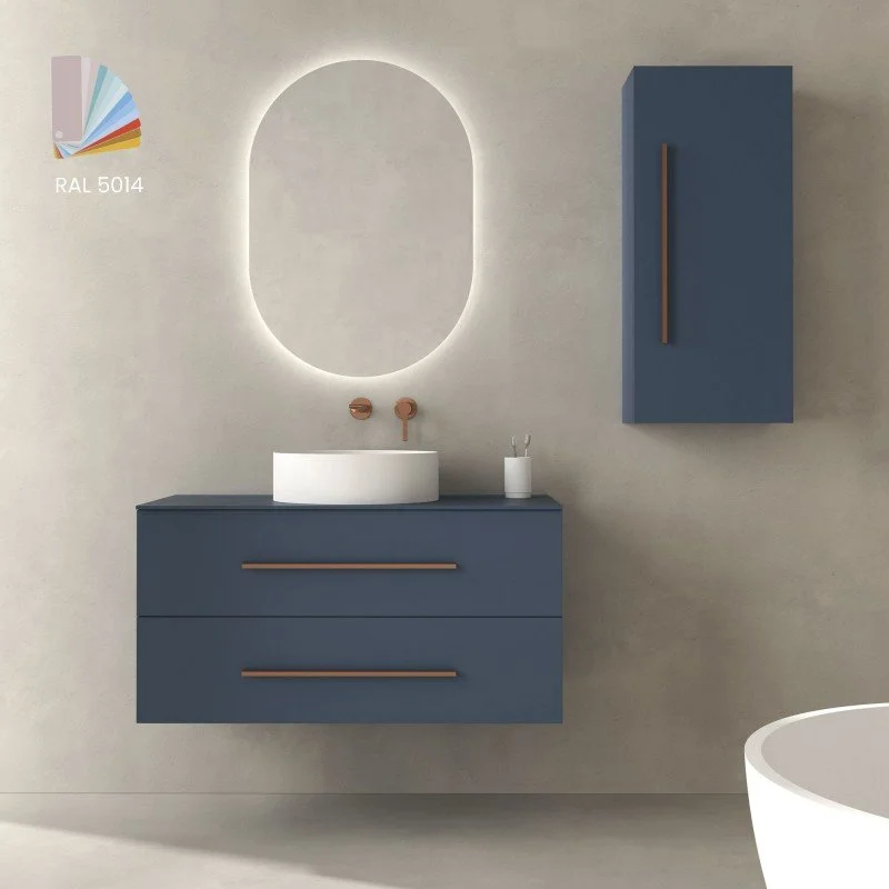 Salle de bain moderne avec un meuble bleu et un miroir lumineux, un lavabo blanc, et un meuble suspendu bleu sur le mur.