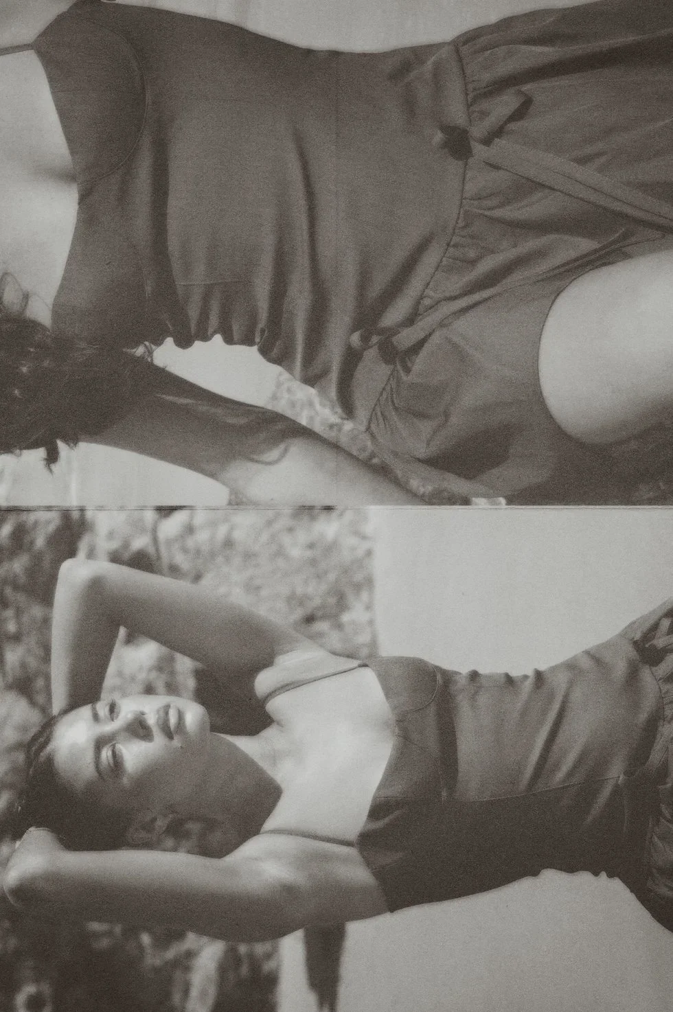 A black and white photo of a woman lying outdoors with eyes closed, resting her head on her arm, wearing a sleeveless top. The photo appears to be vintage or artistic in style.