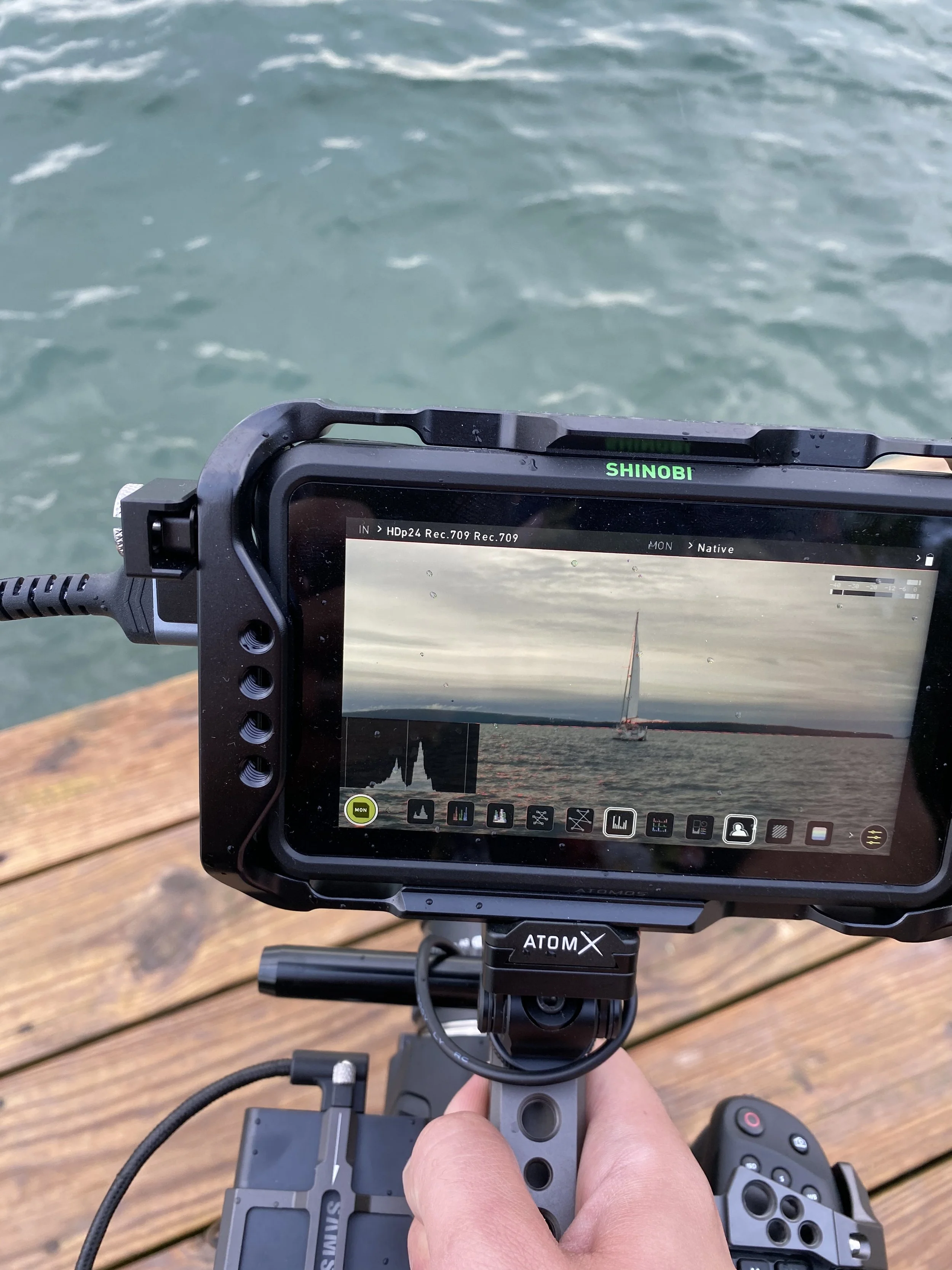 Bone Hook Media camera rig filming water at sunset with a sailboat reflection