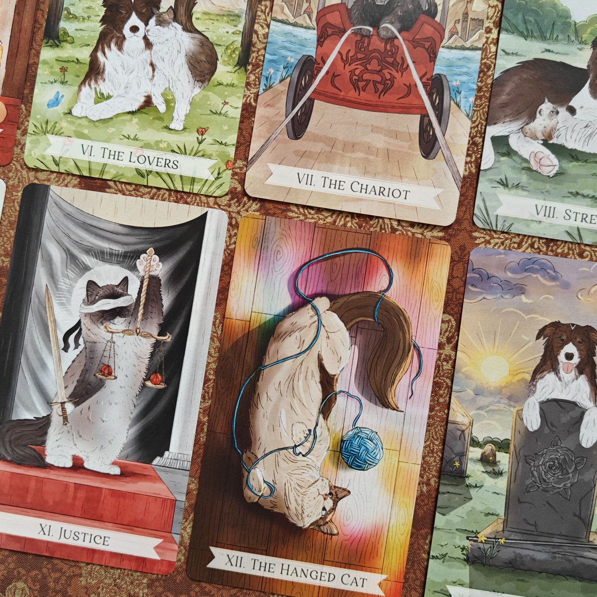 A collection of Tarot cards with animal illustrations, including dogs, cats, and a horse. The visible cards are "The Lovers," "The Chariot," "Street Dog," "Justice," and "The Hanged Cat."